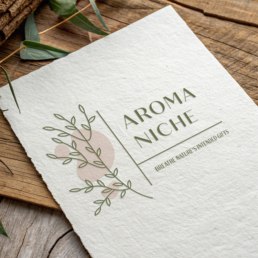 Elegant Aroma Niche logo design featuring botanical illustrations in soft green tones on textured paper mockup with natural wooden background and eucalyptus leaves